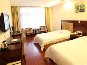 A hotel room with two beds, a desk with a chair, a television, and a painting on the wall. - Greentree Inn Gansu Tianshuilantiancheng Square Hotel (Tianshui)