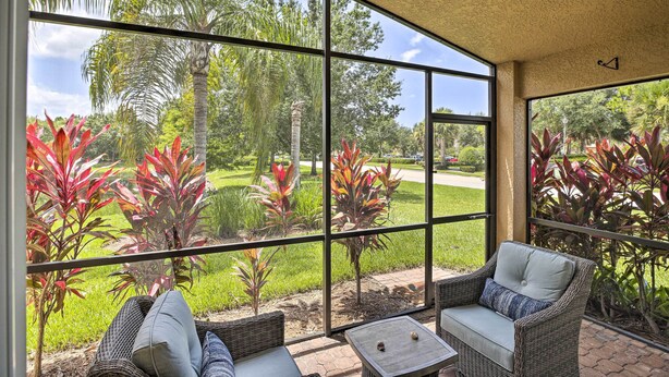 A covered patio with wicker furniture and a view of a lush garden. - Bright & Airy Fort Myers Home w/ Pool Access! (Fort Myers)