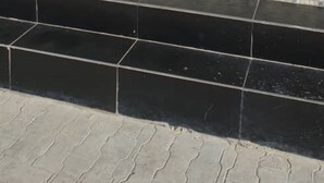 Una habitación con piso de baldosas, una puerta blanca y una ventana con persianas azules.