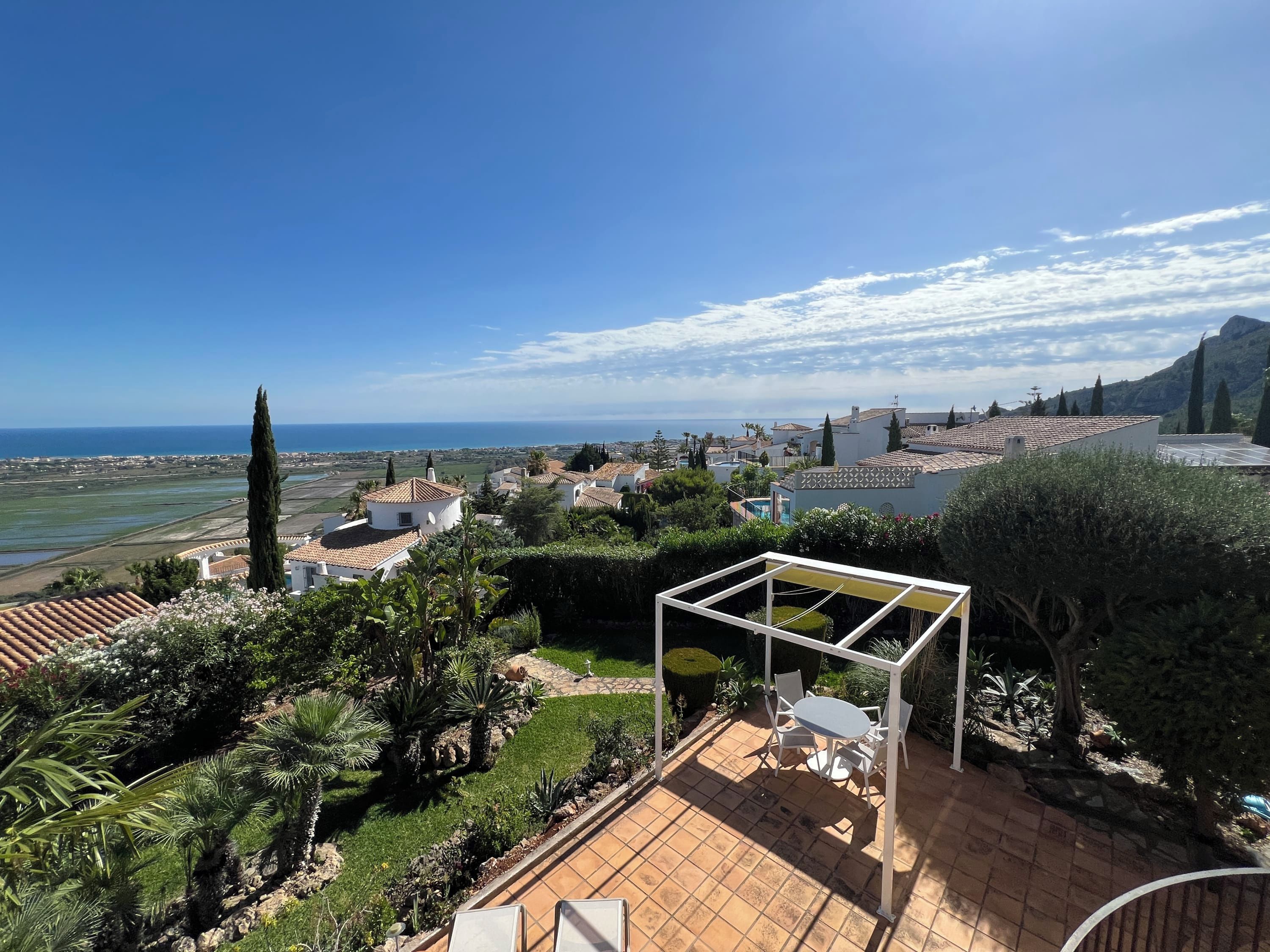 Une terrasse dotée d’une pergola, de sièges et offrant une vue sur la mer et la ville.