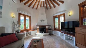 A spacious living room with a fireplace, a television, and a sofa. - T-0121, Canarios, Fantastic villa with panoramic sea views (Denia)