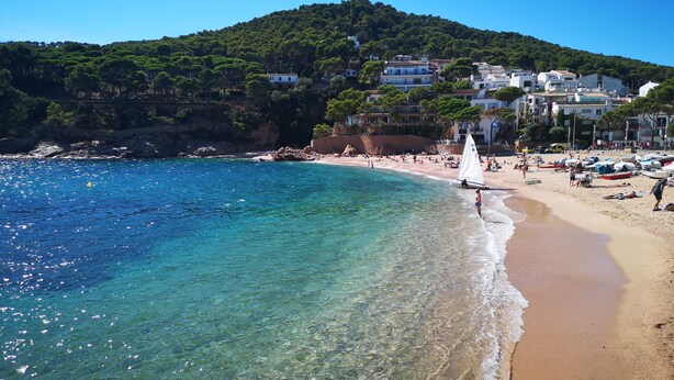 A beach with clear turquoise water, a sandy shore, and buildings in the background. - AMAZING VILLA with, chimney, heating, private swimming pool & great views. (Calonge)