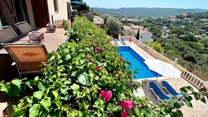A poolside area with wicker furniture, a view of the countryside, and a clear blue sky. - AMAZING VILLA with, chimney, heating, private swimming pool & great views. (Calonge)