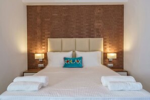 A hotel room with a large bed, two bedside tables, and a wooden headboard.