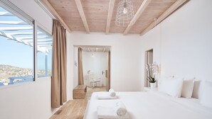 Un dormitorio moderno con una cama grande, suelo de madera, vistas por una ventana y techo de madera.
