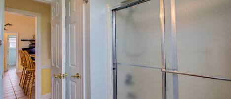A room with a white door, a frosted glass window, and a tiled floor.