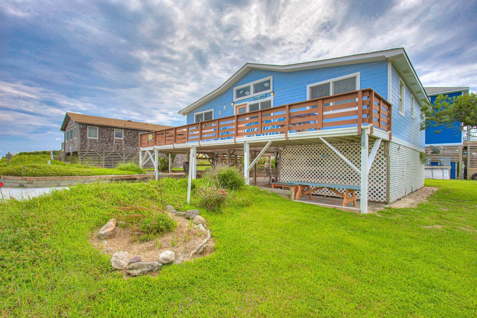A two-story house with a wooden deck and a small garden area.