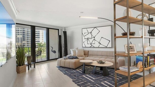 A modern living room with a sofa, coffee table, and a bookshelf. - Beachfront 2BR/2BA condo with heated pool, WiFi, and Marco Island views. (Marco Island)
