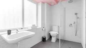 Un baño moderno con lavamanos, inodoro y zona de ducha blancos.
