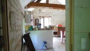 A room with a sloped ceiling, a window, a wooden table, and a chair. - RENAISSANCE cottage (Courchamps)
