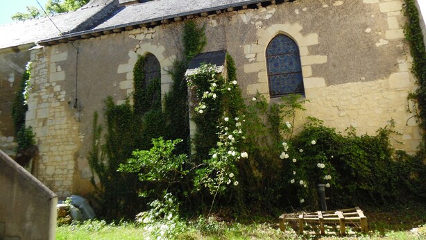 A stone building with arched windows and a tiled roof, surrounded by greenery and a wooden bench. - RENAISSANCE cottage (Courchamps)