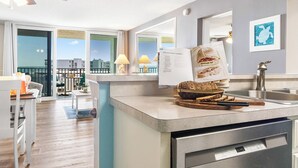 Una cucina moderna con lavastoviglie integrata, un tagliere di legno con pane e un libro di ricette sul bancone.