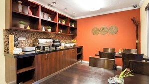 Eine moderne Küche mit Buffetaufstellung, Holzschränken und einer gefliesten Rückwand.