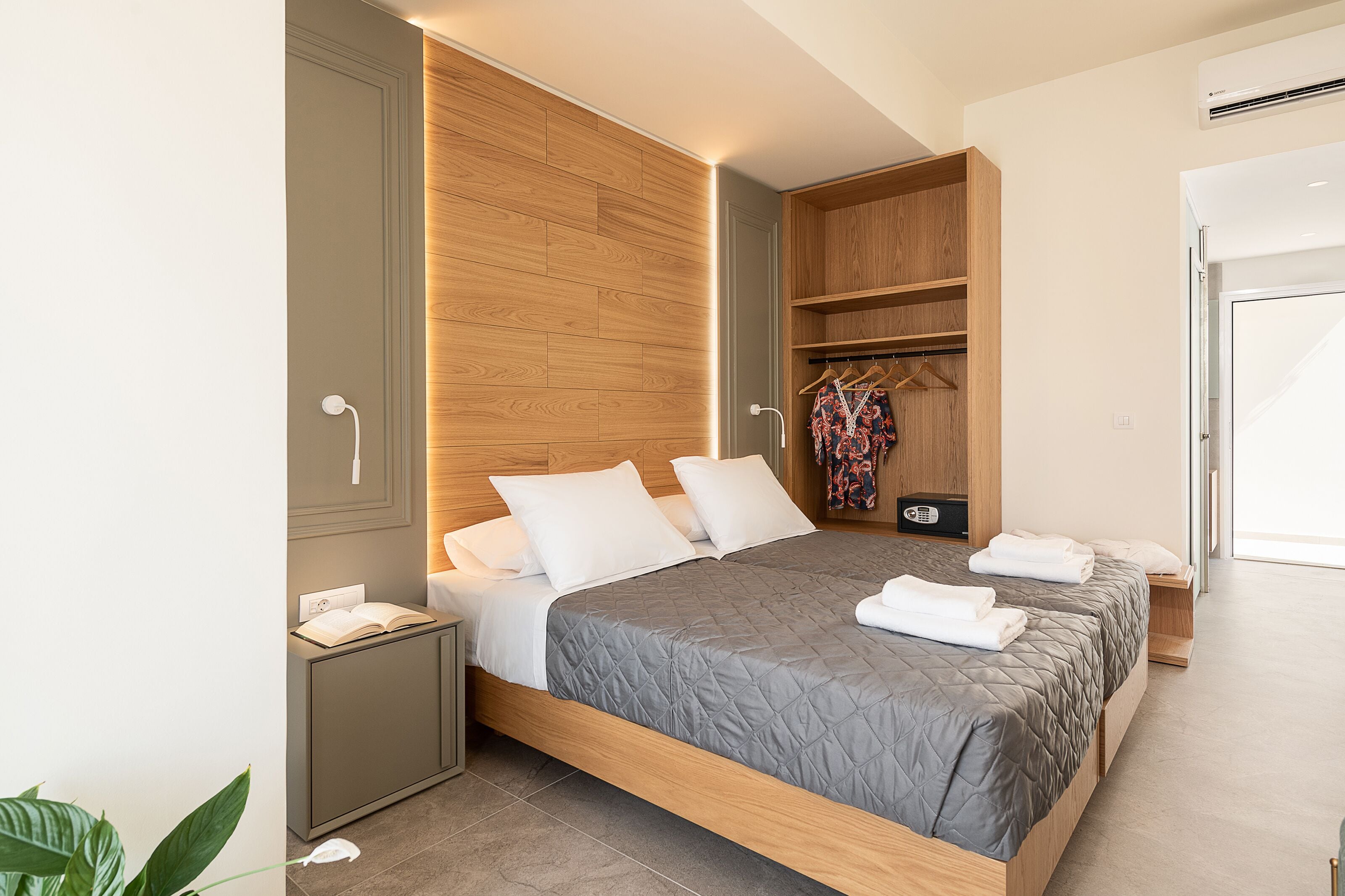 Un dormitorio moderno con una cama grande, armario empotrado y mesita de noche.