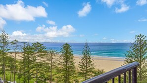 A beach with a clear view of the ocean and a distant city skyline. - Calypso Towers 901 - Coolangatta Beachfront - Min. 3 night stays! (Coolangatta)