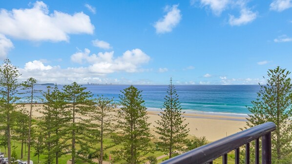 A beach with a clear view of the ocean and a distant city skyline. - Calypso Towers 901 - Coolangatta Beachfront - Min. 3 night stays! (Coolangatta)