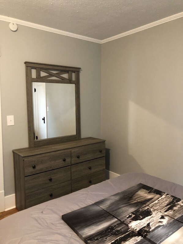 A bedroom with a bed, a dresser, and a mirror. - Torch Lake Oasis: Serene Views & Waterfront Bliss Await! (Rapid City)