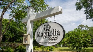 A sign for Magnolia Court, indicating it is a luxury suites location. - Original Craftsman Cottage, at Magnolia Court Suites (Beaufort)