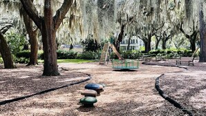 A park with a playground, benches, and a covered area.