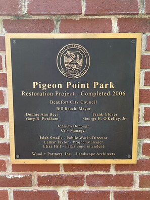 Une plaque commémorative, fixée à un mur de briques, marque l’achèvement du projet de restauration du parc de Pigeon Point en 2006.