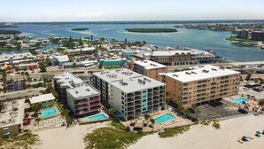 Ein Küstenhotel mit mehreren Gebäuden, einem Schwimmbad und einem Strandabschnitt.
