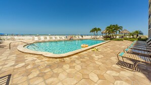 Ein Poolbereich mit Liegestühlen und Blick auf den Ozean.