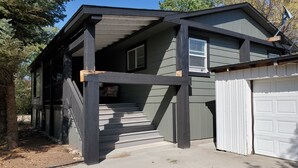 A two-story house with a covered porch and a garage. - Beautiful Home in Glendo (Glendo)