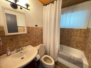 A bathroom with a sink, toilet, and bathtub.