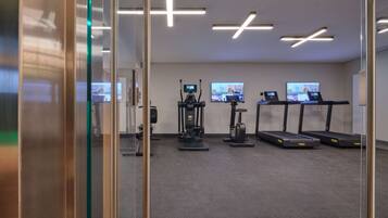 A modern gym with treadmills, a stationary bike, and a rowing machine.