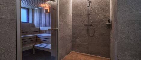 Un baño moderno con ducha, banco y zona de sauna.