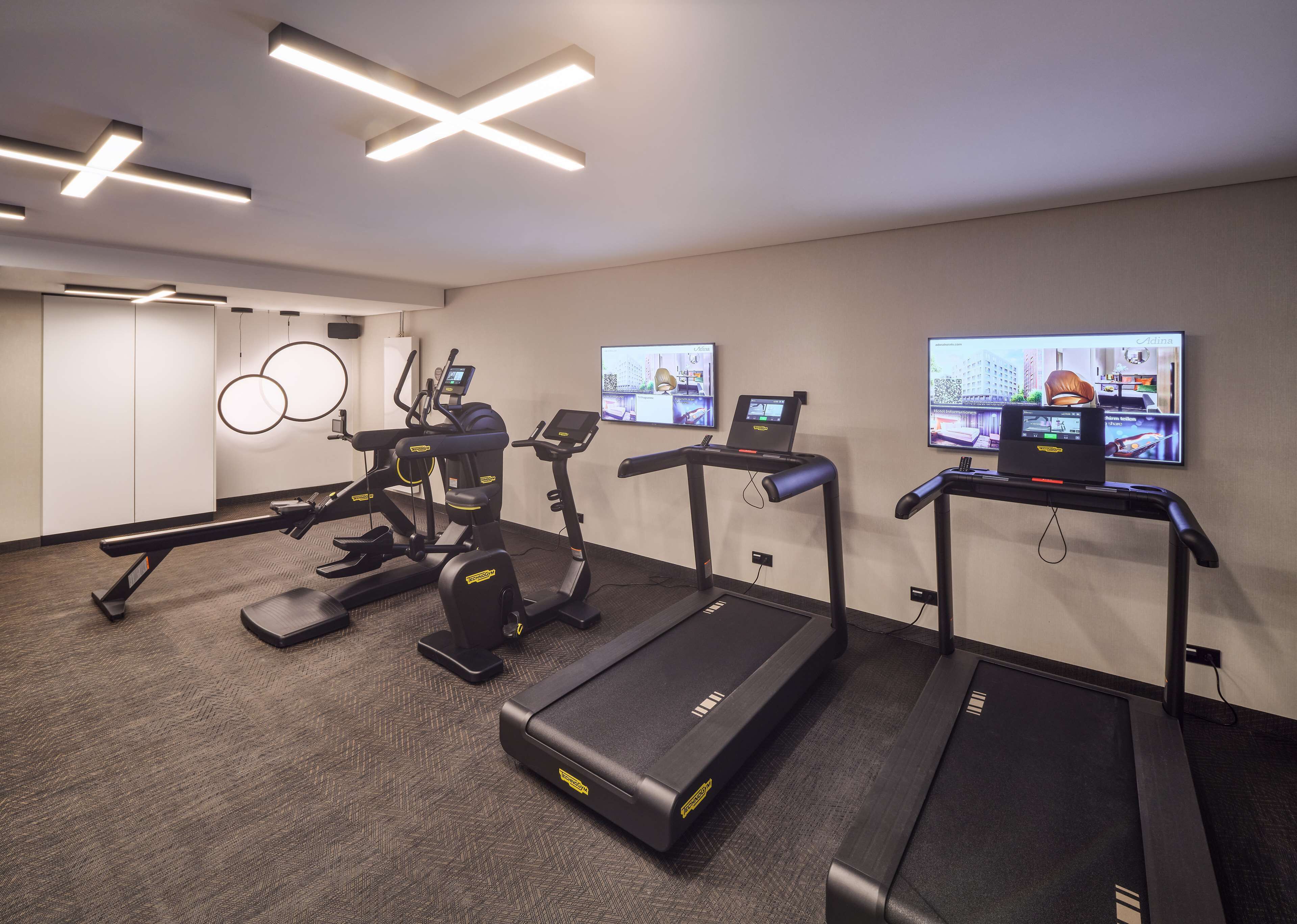 A modern gym with treadmills, elliptical machines, and a stationary bike.