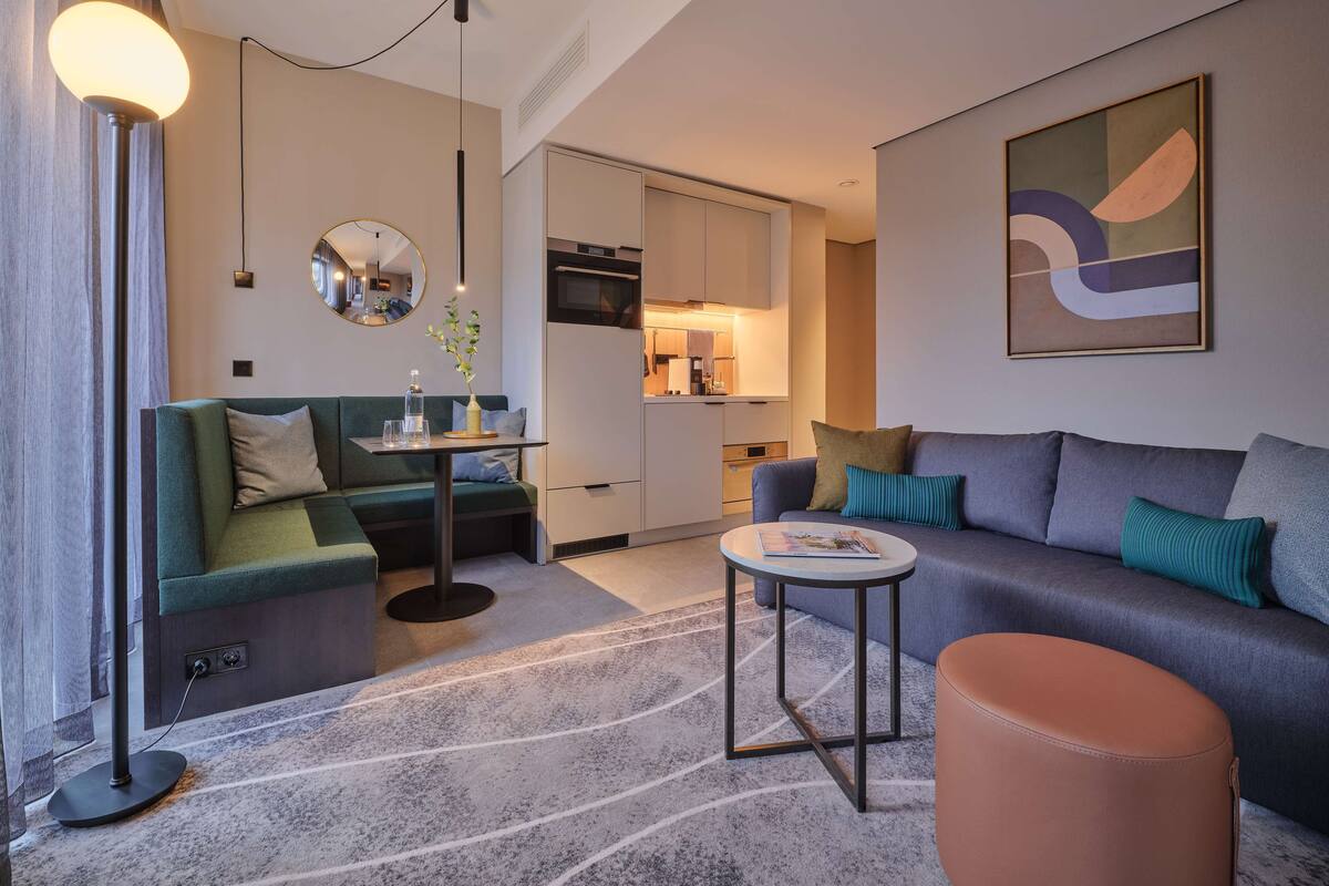 Ein modernes Wohnzimmer mit einer Couch, einem Couchtisch und einer Stehlampe.