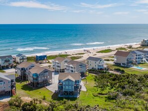 A coastal residential area with multiple two-story houses, some with balconies, near a beach with a clear view of the ocean. - Sunset Cove | Sound Views + Walk to the Beach! (North Topsail Beach)