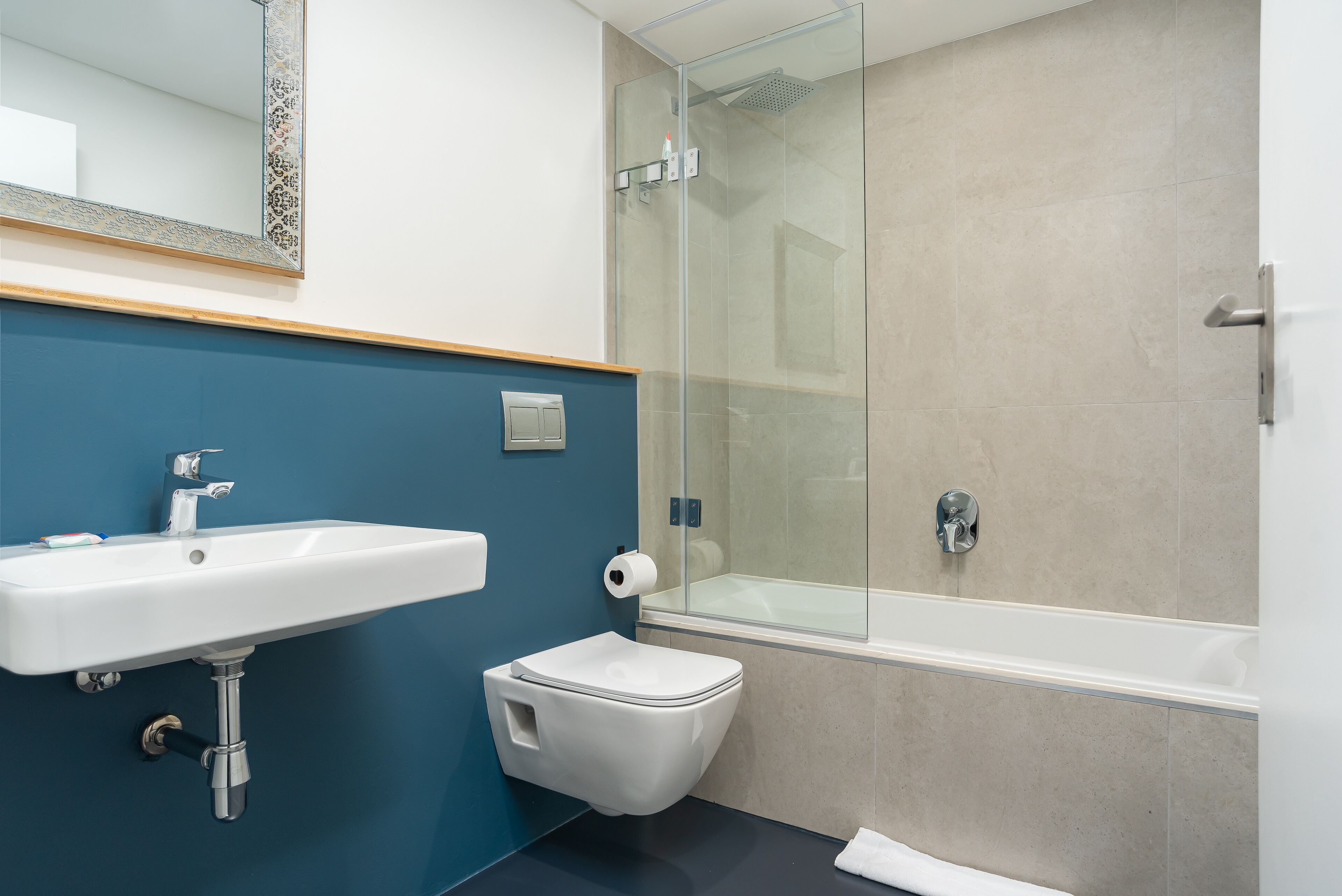 A modern bathroom with a sink, toilet, and glass-enclosed shower.