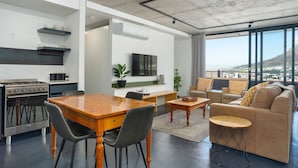 Ein modernes Wohnzimmer mit Essbereich, Küche und einer Sitzecke mit Blick.
