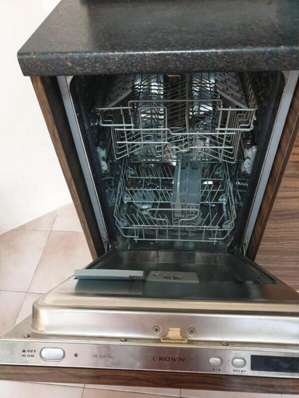 An open dishwasher with a stainless steel finish and a control panel with buttons labeled "OFF," "ON," "WASH," and "DELAY."