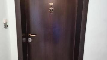 A dark wooden door with a doorbell and a mail slot.