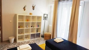 A room with two beds, a white shelving unit with various items, a floor lamp, and a window with curtains. - A few Steps from Syntagma and Plaka (Athens)