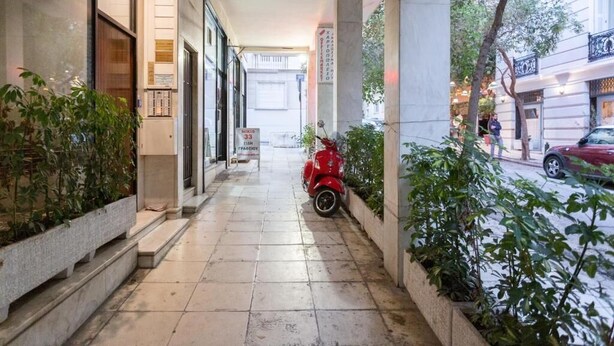 A corridor with tiled flooring, potted plants, and a red scooter parked on the right. - A few Steps from Syntagma and Plaka (Athens)