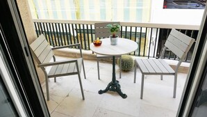 A balcony with two chairs, a small round table, a potted plant, and a cactus. - A few Steps from Syntagma and Plaka (Athens)