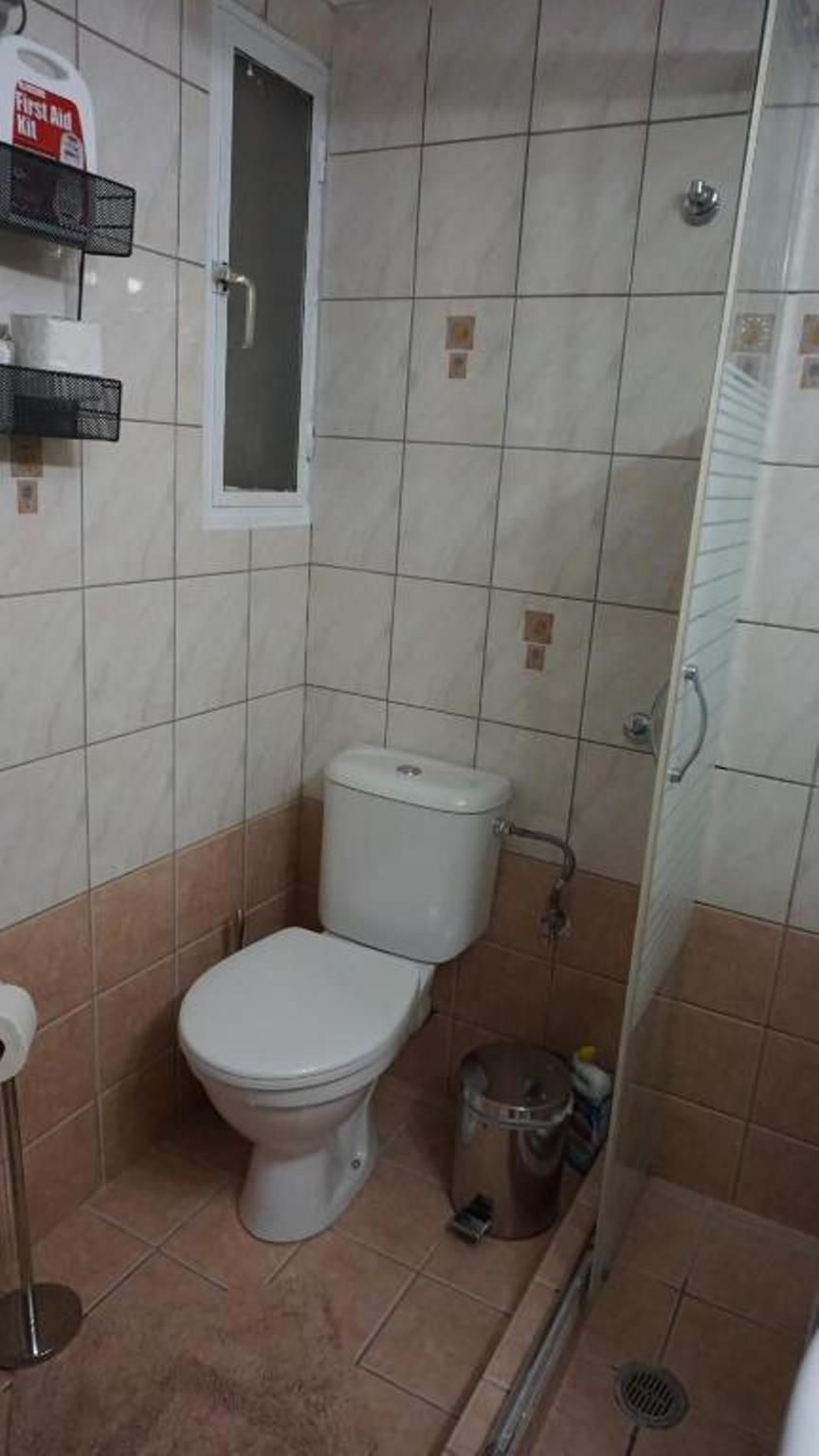Une petite salle de bain comprenant des toilettes, un bidet, une poubelle et un espace douche.