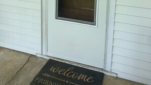 Une porte blanche avec une enseigne indiquant « The Puckett House » au-dessus d’une fenêtre.