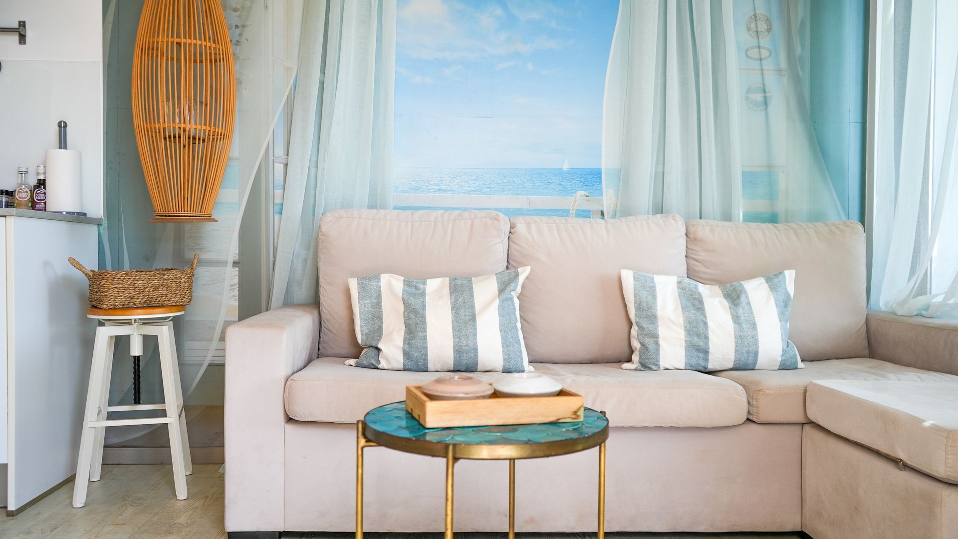 A cozy living room with a sofa, cushions, a small table, and a wicker basket.
