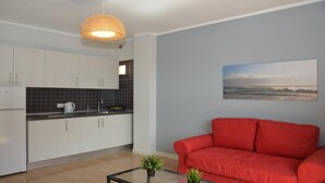 Une cuisine moderne avec des armoires blanches, un pare-feu noir et un luminaire suspendu.