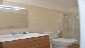 Une salle de bain avec un lavabo blanc, un miroir et des toilettes.