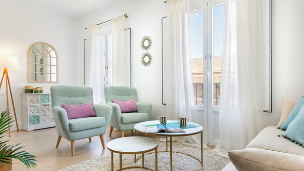 A modern living room with two armchairs, a sofa, a round coffee table, and a side table with a lamp. - Genteel Home Juan Rabadan I (Seville)