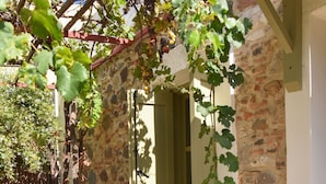 A stone building with a window and a wooden fence. - Stone House Kleio Kos  (Αντιμάχεια)
