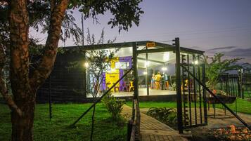 A reception area with a glass enclosure, a signboard, and a few people seated outside.