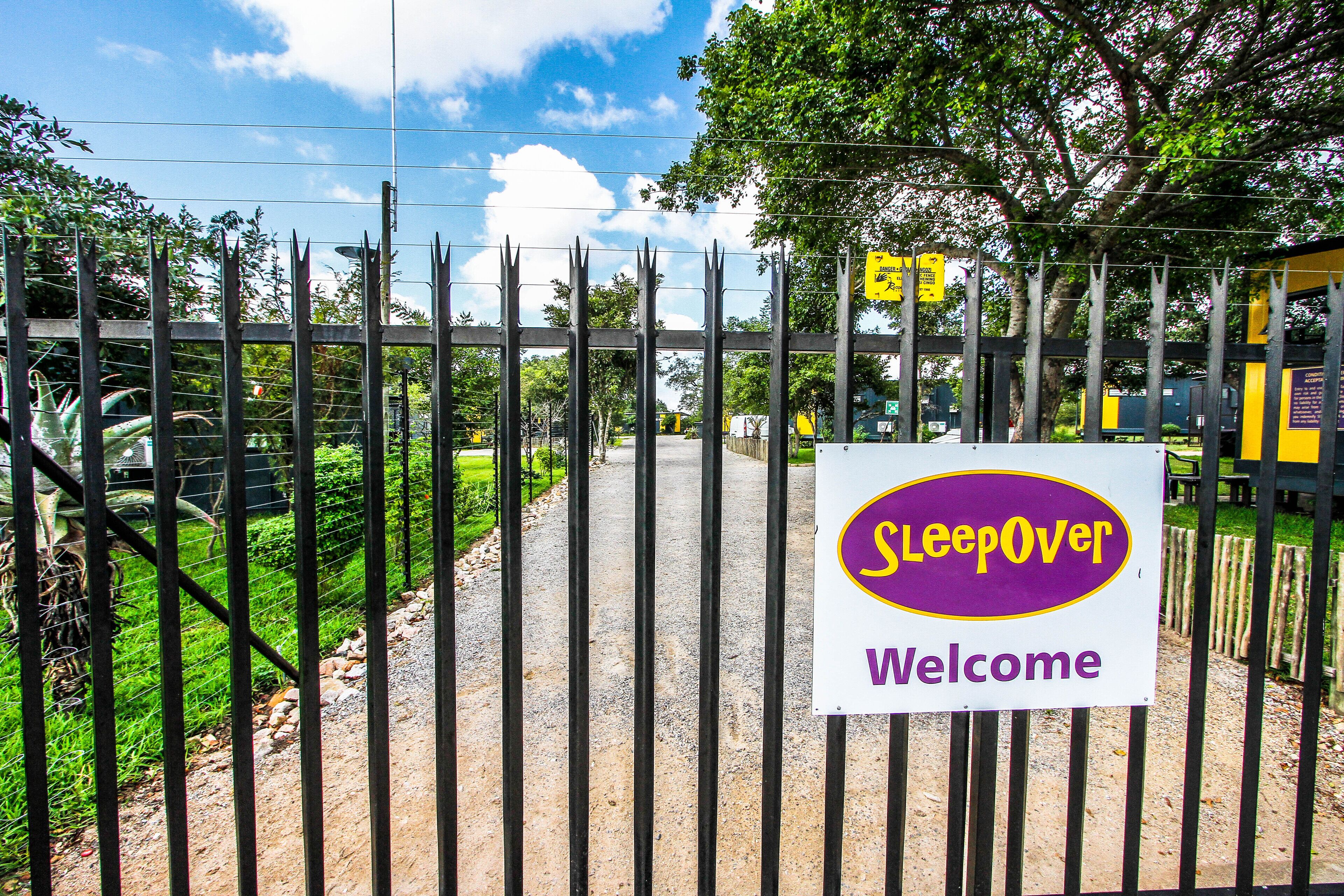 A gated entrance with a sign reading "Sleepover Welcome".