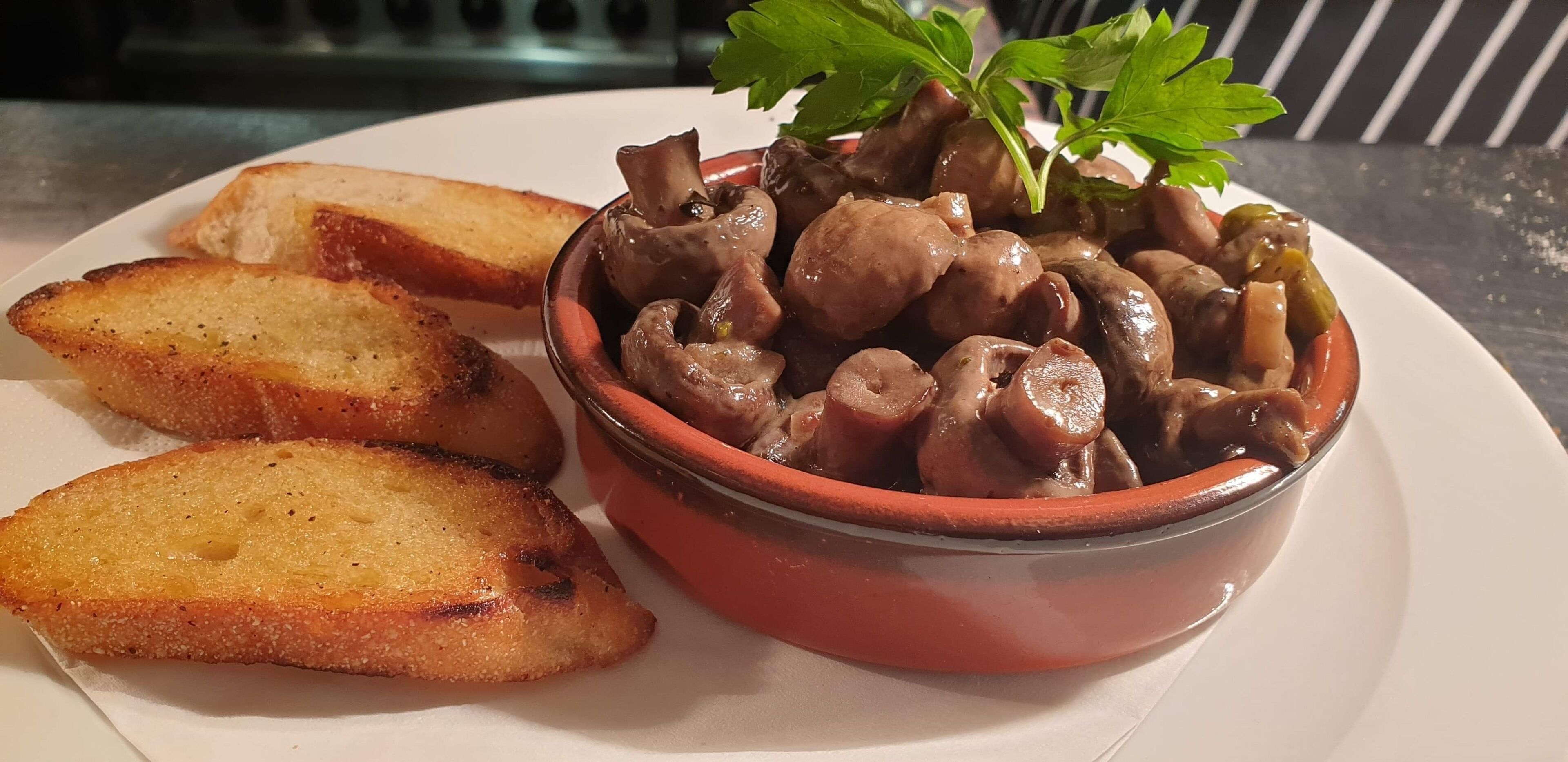 Un plato con un bol de setas y pan tostado.